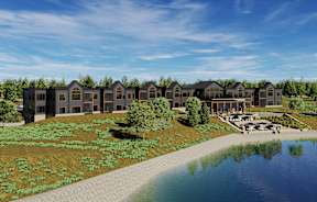 A row of houses are built on a hill with a lake in front.