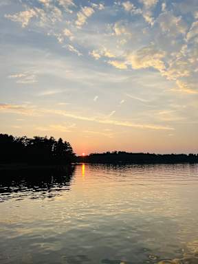 A serene lake with a sunset in the background.