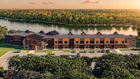 A large building with a parking lot in front of it.