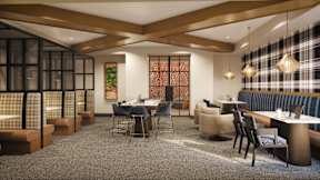 A modern dining room with a long table and chairs.