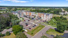 an aerial view of a parking lot in front of several apartment buildings