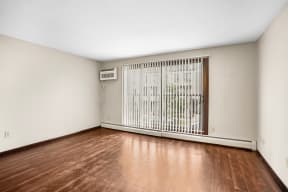 the spacious living room with wood flooring and a large window