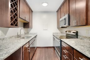 a kitchen with wood cabinets and granite counter tops and a sink and stove