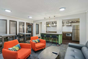 a living room with couches and chairs and a kitchen