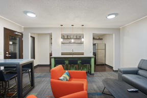 a living room with orange couches and a kitchen with a green bar