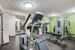 a gym with cardio equipment and weights at the enclave at university campuses