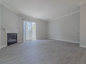 an empty living room with a fireplace and a sliding glass door at Warner Center Townhomes, Canoga Park, 91303