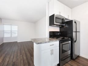 an empty kitchen with a stove refrigerator and microwave  at Skyline Heights LLC, Daly City, CA