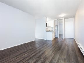 an empty living room with white walls and wood floors  at Skyline Heights LLC, Daly City