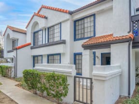 a white building with blue windows and a sidewalk  at The Resort at Encinitas Luxury Apartment Homes, Encinitas, CA