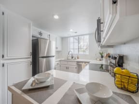 a kitchen with white cabinets and a stainless steel refrigerator  at The Resort at Encinitas Luxury Apartment Homes, Encinitas