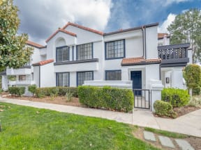a white house with a yard and a sidewalk  at The Resort at Encinitas Luxury Apartment Homes, Encinitas