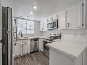 a kitchen with white cabinets and stainless steel appliances  at The Resort at Encinitas Luxury Apartment Homes, Encinitas, California