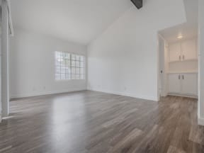 an empty living room with white walls and wood floors  at The Resort at Encinitas Luxury Apartment Homes, California