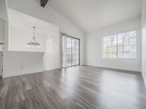 the living room and dining room of an empty house with a large window  at The Resort at Encinitas Luxury Apartment Homes, Encinitas, CA