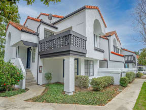 a white house with a balcony and a sidewalk  at The Resort at Encinitas Luxury Apartment Homes, Encinitas, 92024