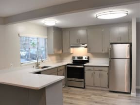 a kitchen with stainless steel appliances and white counter tops at Trailhead Apartments at Tam Junction, California, 94941