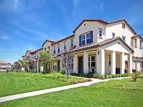 a row of houses on the side of a green lawn at The Vines at Riverpark, LLC, Oxnard California