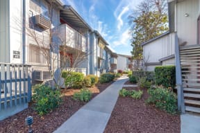 a walkway between two buildings with a blue sky in the background at Sunnyvale Crossings Apartments, LLC, Sunnyvale California