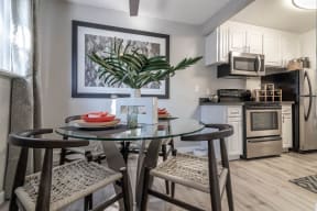 a kitchen with a glass table with three stoolsat Sunnyvale Crossings Apartments, LLC, Sunnyvale California