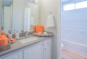 a bathroom with a sink and a shower and a mirror at Sunnyvale Crossings Apartments, LLC, Sunnyvale, CA