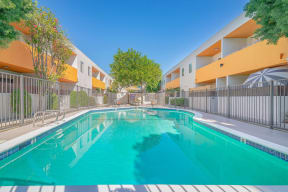 a swimming pool in front of an apartment building with a pool at The Flats on Addison, California, 91423