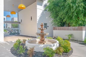 a fountain in a courtyard in front of a building at The Flats on Addison, Sherman Oaks