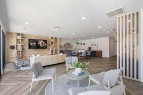 A modern living room with a grey sofa, white chairs, and a coffee table at Latitude Apartments at Mission Valley Apartments, San Diego, CA