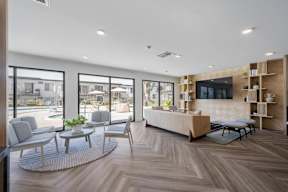 A modern living room with a large window overlooking a pool and patio area at Latitude Apartments at Mission Valley Apartments, San Diego