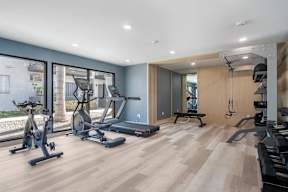 A spacious home gym with a variety of exercise equipment at Latitude Apartments at Mission Valley Apartments, California, 92120