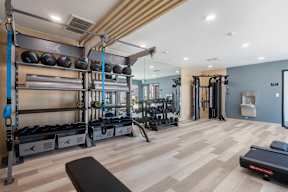 A gym with a variety of equipment including weights and a treadmill at Latitude Apartments at Mission Valley Apartments, San Diego, 92120