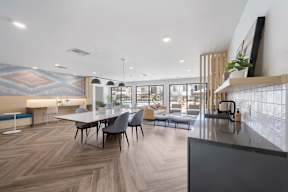A modern dining area with a long table and chairs at Latitude Apartments at Mission Valley Apartments, California