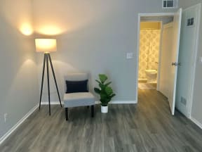 a living room with a chair and a potted plant  at The Marq Apartments LLC, Los Angeles, California