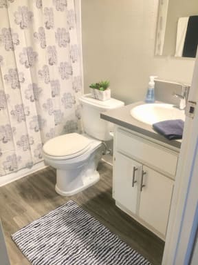 a bathroom with a toilet and a sink and a shower curtain  at The Marq Apartments LLC, Los Angeles