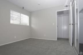an empty bedroom with a closet and a window  at The Marq Apartments LLC, California