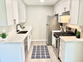 a kitchen with white cabinets and a stainless steel refrigerator at BLVD Apartments LLC, California