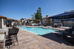 a swimming pool with chairs and umbrellas at The Bryant, California, 92887