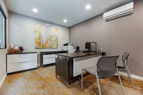 an office with two desks and two chairs and a painting on the wall at Citra Apartments LLC, San Diego, CA