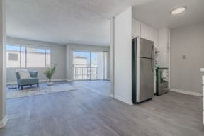 an open living room and kitchen with a stainless steel refrigerator at Citra Apartments LLC, San Diego, CA, 92107