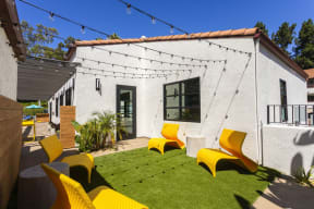 a backyard with yellow chairs and a white house at La Jolla Blue, San Diego