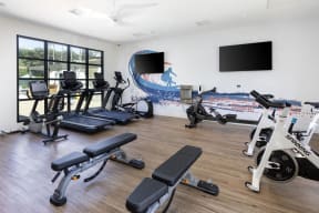 a gym with cardio equipment and a wall mural of the beach at La Jolla Blue, San Diego