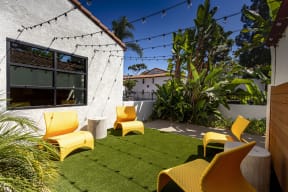 a backyard with yellow chairs and a green lawn at La Jolla Blue, San Diego, CA 92122