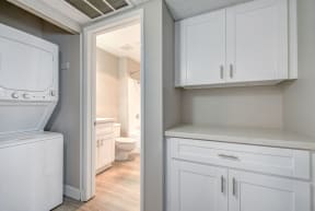 a laundry room with white cabinets and a white washer and dryer at La Jolla Blue, San Diego California
