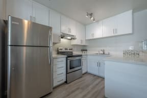 a white kitchen with stainless steel appliances and white cabinets at Napa Green Apartments LLC, California