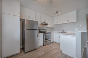 a white kitchen with stainless steel appliances and white cabinets at Napa Green Apartments LLC, Napa California