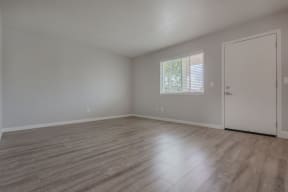 an empty living room with wood floors and a window at Napa Green Apartments LLC, Napa, CA 94559