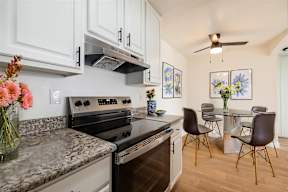 A kitchen with a black stove top oven and a marble counter top.at Summerhill Place Apartments, Union City, CA 94587