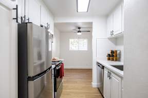 A kitchen with a black fridge and white cabinets.