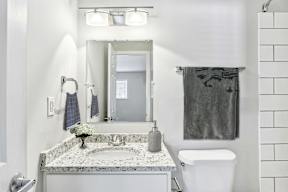 A bathroom with a marble countertop and a white toilet.