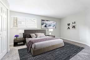 A bedroom with a large bed and a painting on the wall.